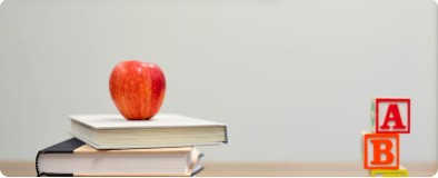 Apple on books next to alphabet blocks