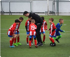 Young soccer players gathered around their coach